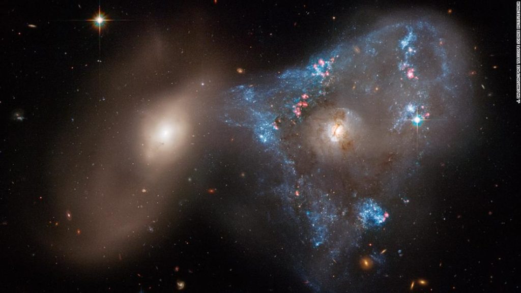 Duas galáxias colidindo formam um triângulo espacial incomum