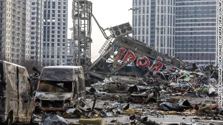 Carros queimados e os escombros de um shopping center após um bombardeio russo na Ucrânia.