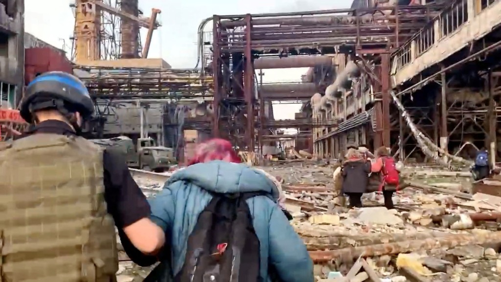 Membros do Regimento Azov caminham com civis durante evacuações lideradas pela ONU da extensa usina siderúrgica Azovstal, quase dois meses em uma guerra de cerco à cidade pela Rússia durante sua invasão, em Mariupol, Ucrânia nesta foto de um post divulgado em 1 Maio de 2022. 