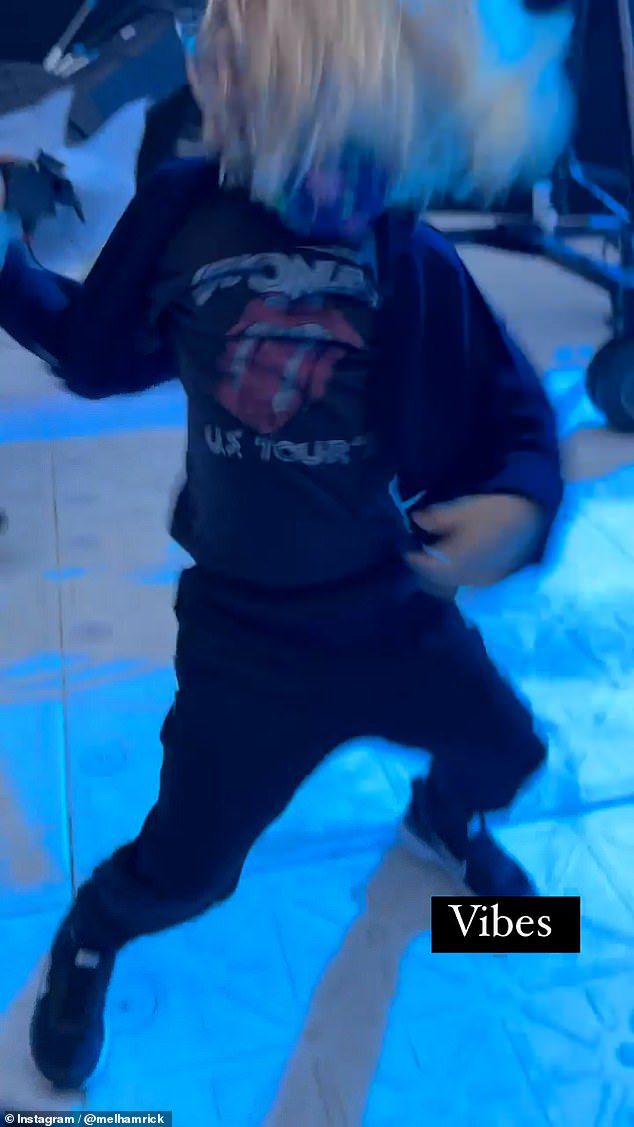 CHEIO DE DIVERSÃO: Deveraux usa uma camiseta dos Rolling Stones com o logotipo icônico da língua e lábio estampado na frente com um cardigã e jeans skinny