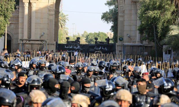 Forças de segurança iraquianas montam guarda enquanto manifestantes tentam invadir a Zona Verde.