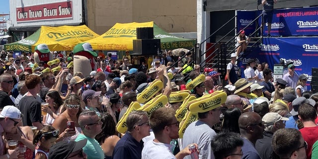 Uma multidão se reúne para assistir ao famoso concurso de comer cachorro-quente de Nathan em Coney Island em 4 de julho de 2022. 
