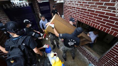 Soldados carregam destroços de uma casa inundada em Seul, Coreia do Sul, em 10 de agosto.