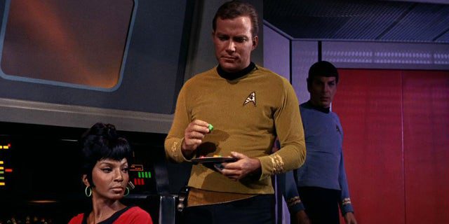 Nichelle Nichols (à esquerda, como Uhura) e William Shatner (como Capitão James T. Kirk) na ponte USS Enterprise em uma cena de "armadilha do homem" O primeiro episódio de "jornada nas Estrelas," que foi transmitido em 8 de setembro de 1966.