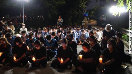 Uma pequena multidão realiza uma vigília à luz de velas em Seul em 11 de agosto para comemorar a morte de uma família depois que sua casa foi inundada em 8 de agosto.