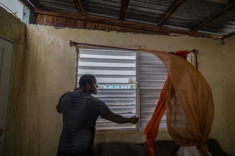 Nelson Sereno protege as janelas de sua casa enquanto os ventos do furacão Fiona sopram em Louisa no domingo.