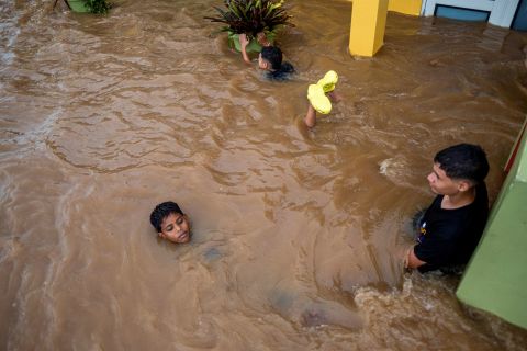 Crianças brincam em uma rua inundada em Salinas na segunda-feira.