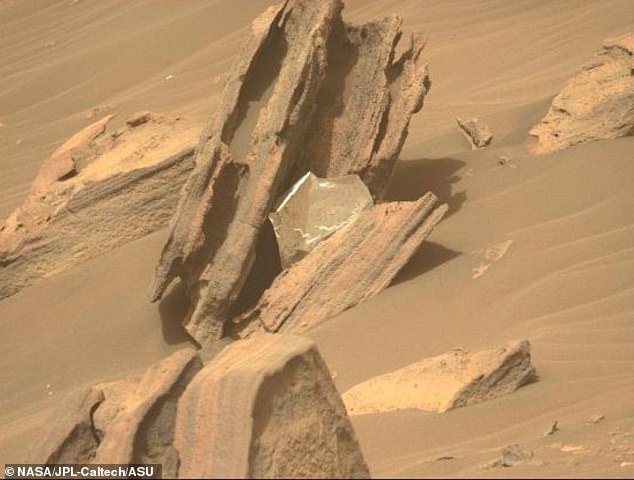 Um cientista estimou que existem 15.694 libras de lixo em Marte.  A maior parte decorre de dispositivos negligenciados como este cobertor térmico que protege a tenacidade da NASA e sobrevive através da atmosfera infernal.