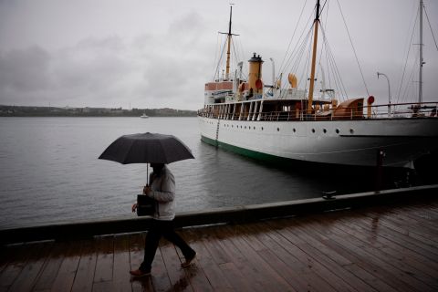 Um pedestre se protege com um guarda-chuva enquanto caminha pela orla de Halifax na sexta-feira.