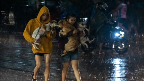 Moradores carregam animais de estimação da família para um centro de evacuação em meio a fortes chuvas na cidade de Marikina, subúrbios de Manila, Filipinas, em 25 de setembro.