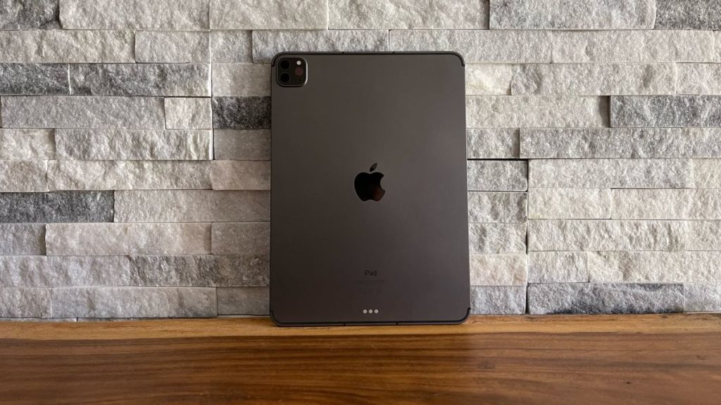 An Apple iPad Pro 11 (2021) from the back, on a wooden surface