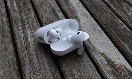Estojo do AirPods Pro 2 aberto em uma mesa com um fone de ouvido pendurado na tampa.