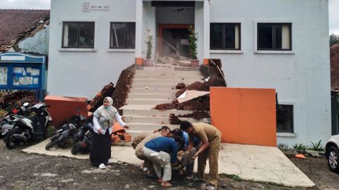 Funcionários municipais em Cianjur evacuam um colega ferido após o terremoto.