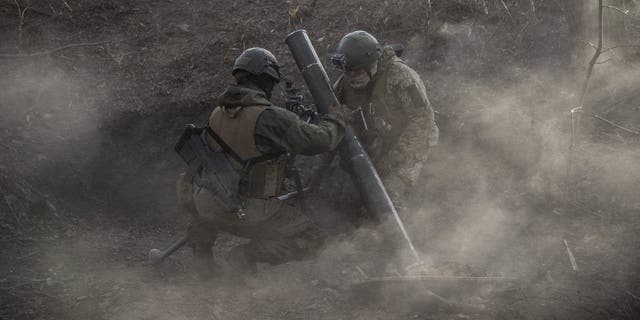 Soldados ucranianos assistem após disparar morteiros na linha de frente de Toritsk em Donbass, Ucrânia, em 2 de dezembro de 2022. 
